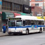 passengers boarding a city bus on a busy street