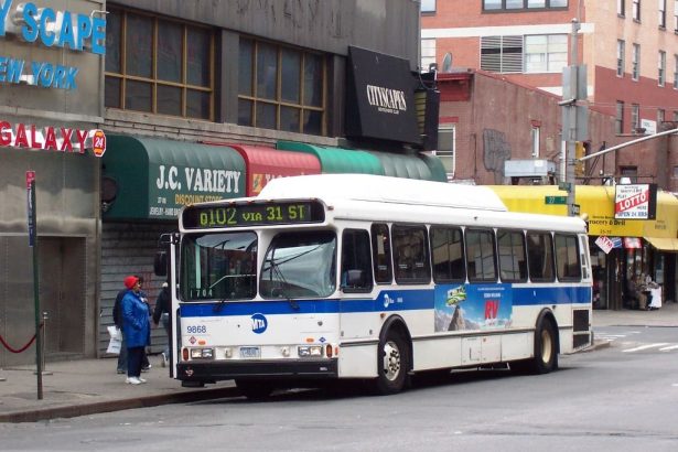 passengers boarding a city bus on a busy street