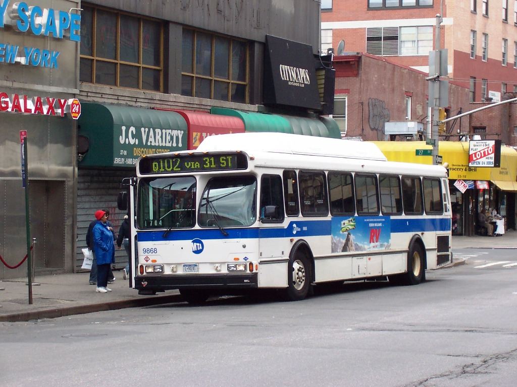 passengers boarding a city bus on a busy street