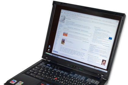 A tablet and laptop sit side by side on a tidy study desk with notebooks.